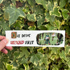 Hand holding a card with text and graphics against a leafy green background