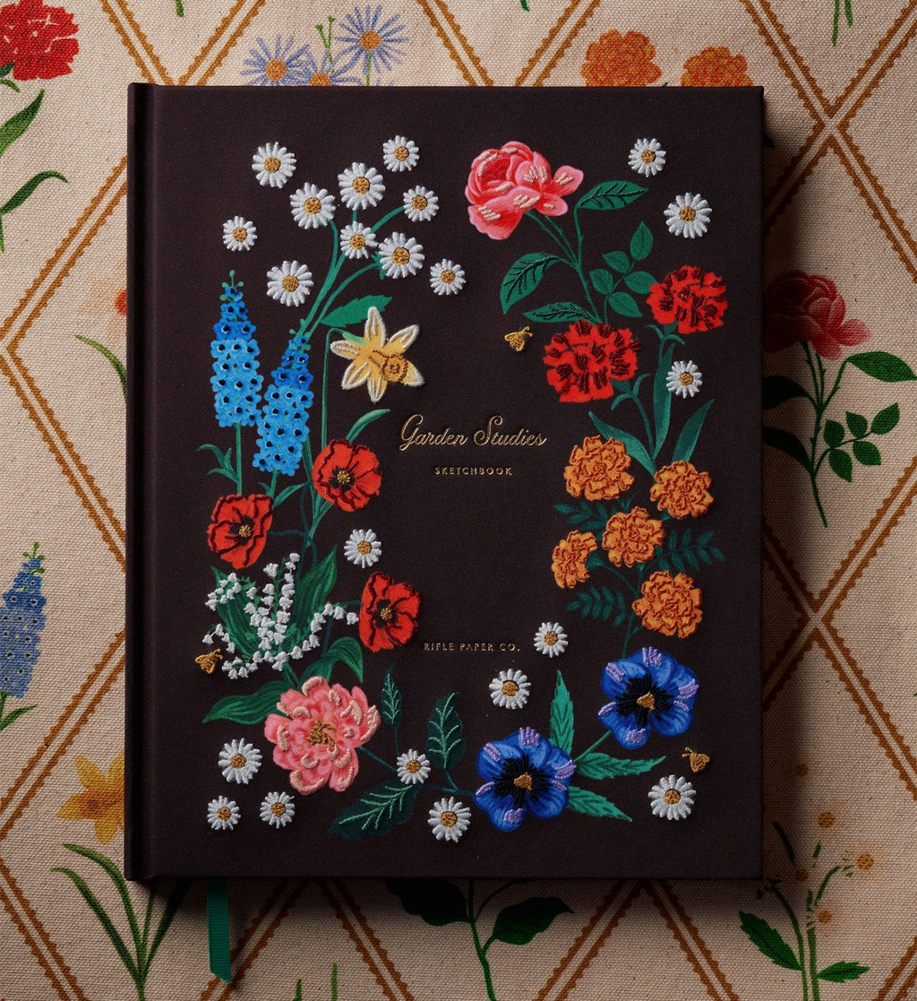 Decorative notebook with embroidered floral designs on a patterned background