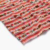 Fabric with red and white striped pattern featuring flowers and gingerbread men on a pink background