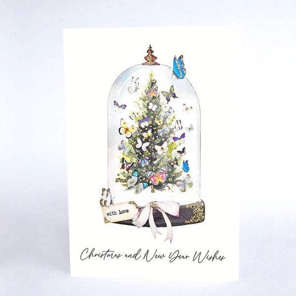 Christmas card with a decorated tree under a glass dome, butterflies, and 'Christmas and New Year Wishes' text.