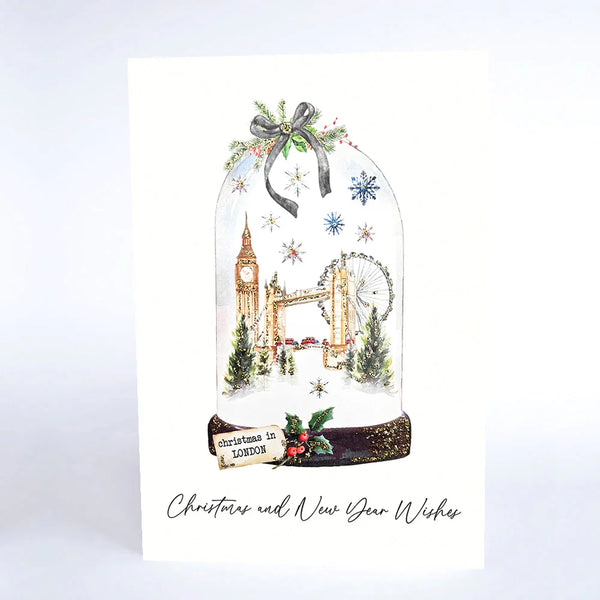 Christmas card with a snowy scene of London landmarks under a glass dome.