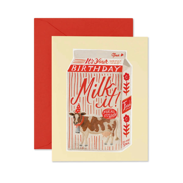 Birthday card with a milk carton design featuring a cow, on a beige background with a red envelope.