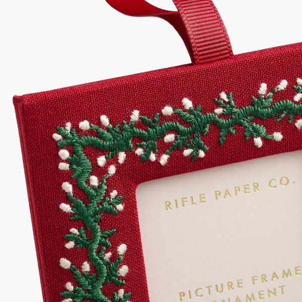 Red embroidered picture frame ornament with green and white design, featuring Rifle Paper Co. branding.