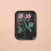 Black tray with floral design on a beige background