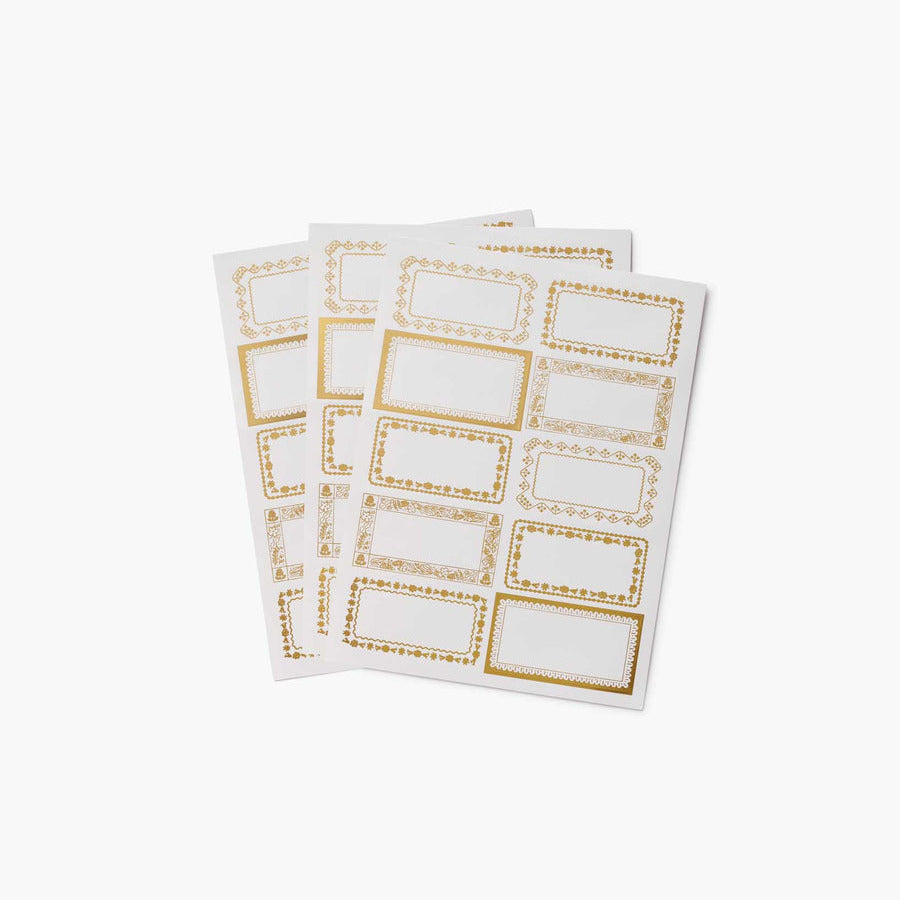 Two sheets of white paper with gold border designs on a white background