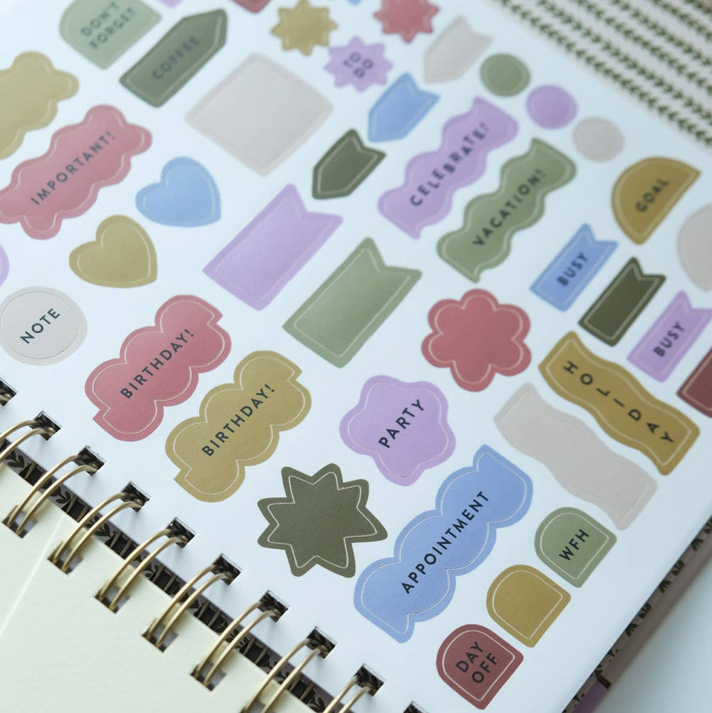 Colorful planner stickers on a spiral-bound notebook