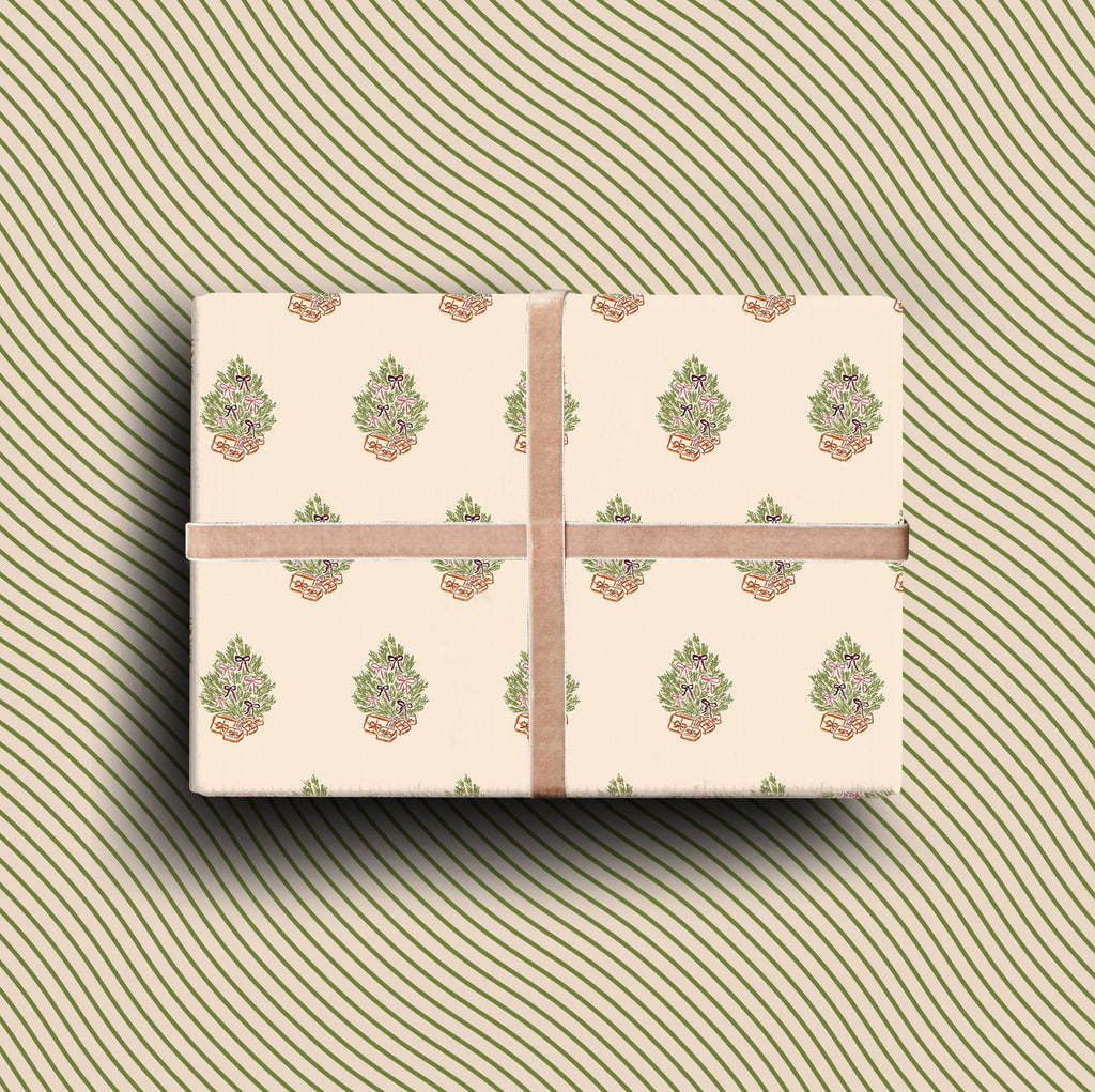Double-sided gift wrap with hand-painted Christmas trees, pink bows, and ochre parcels on a neutral recycled paper background.