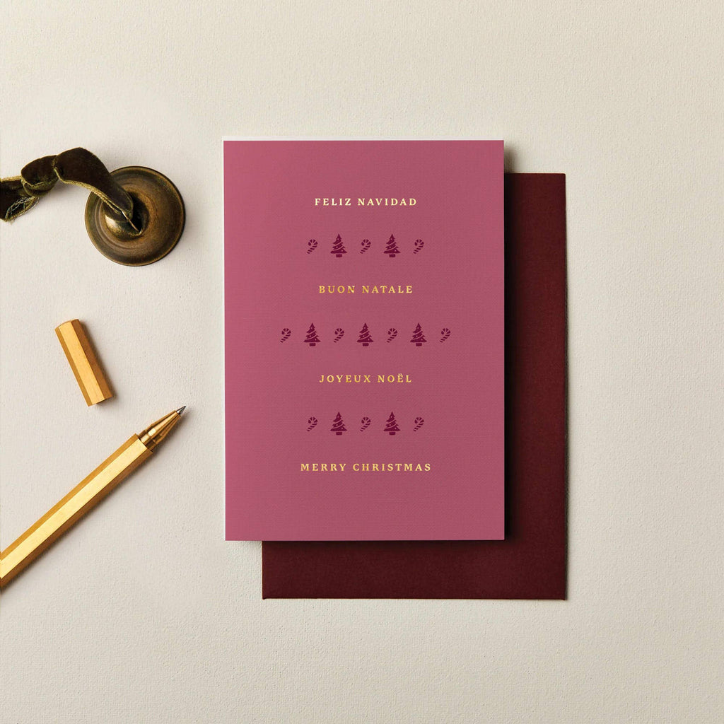 Burgundy A6 Christmas card with gold foil typography, festive icons, and textured cardstock with a matching envelope.