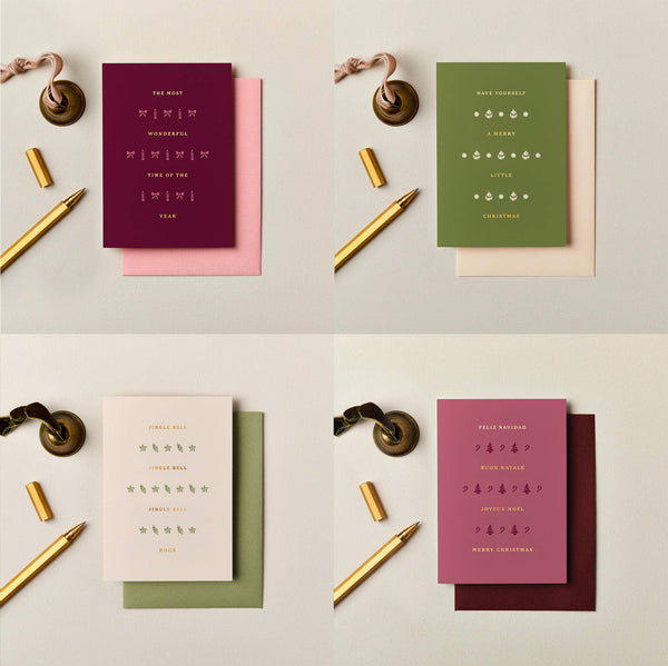 Four luxury A6 Christmas cards in burgundy, olive, pink, and cream with metallic foil typography and festive icons.
