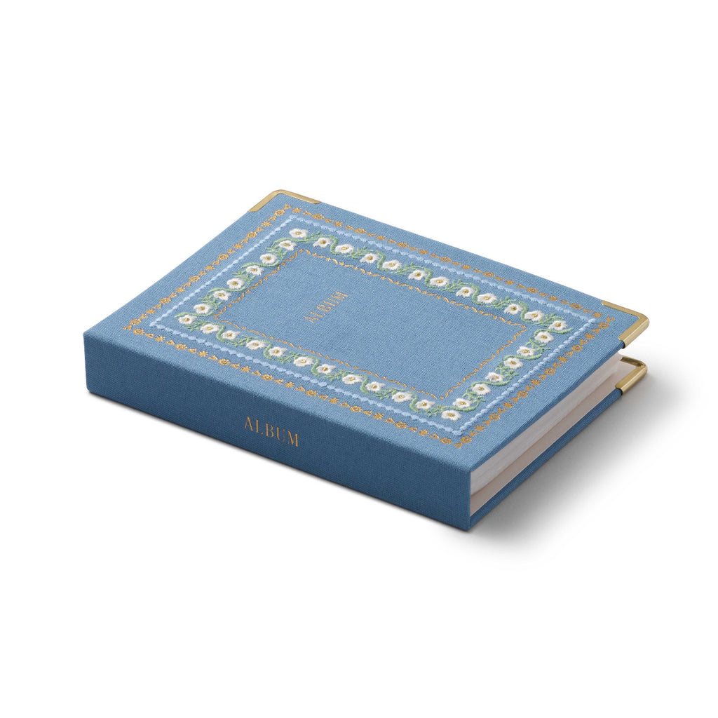 Blue book with decorative gold edges on a white background