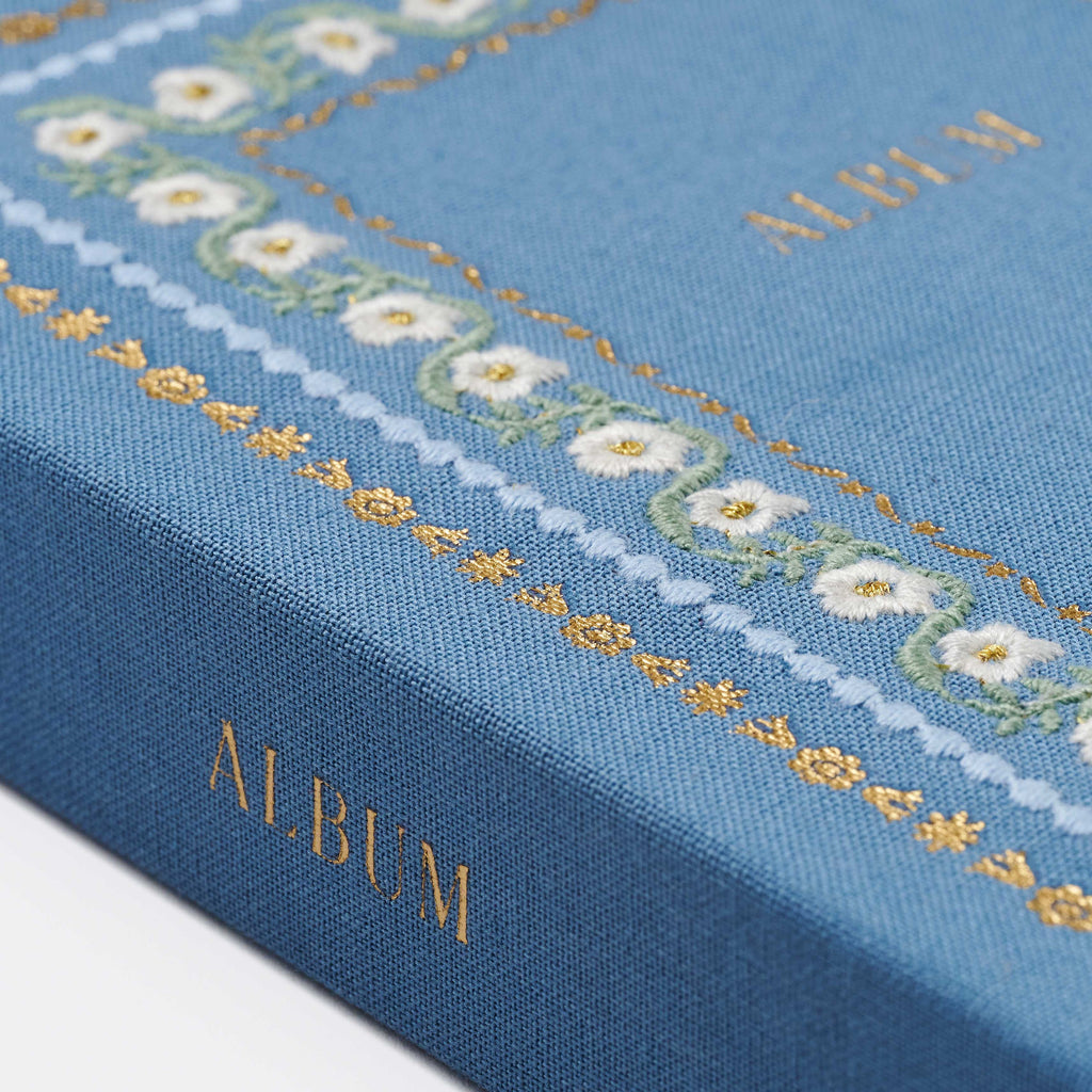 Blue album with floral embroidery on a white background