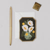 Decorative card with floral design, pen, and seal on a light gray background