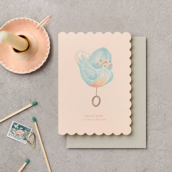 Greeting card with a bird illustration on a textured surface with matches and a stamp.