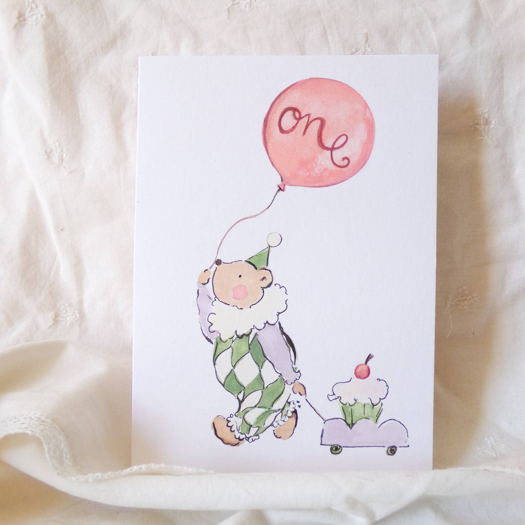 Greeting card with a cartoon character holding a pink balloon and a cupcake on a white background