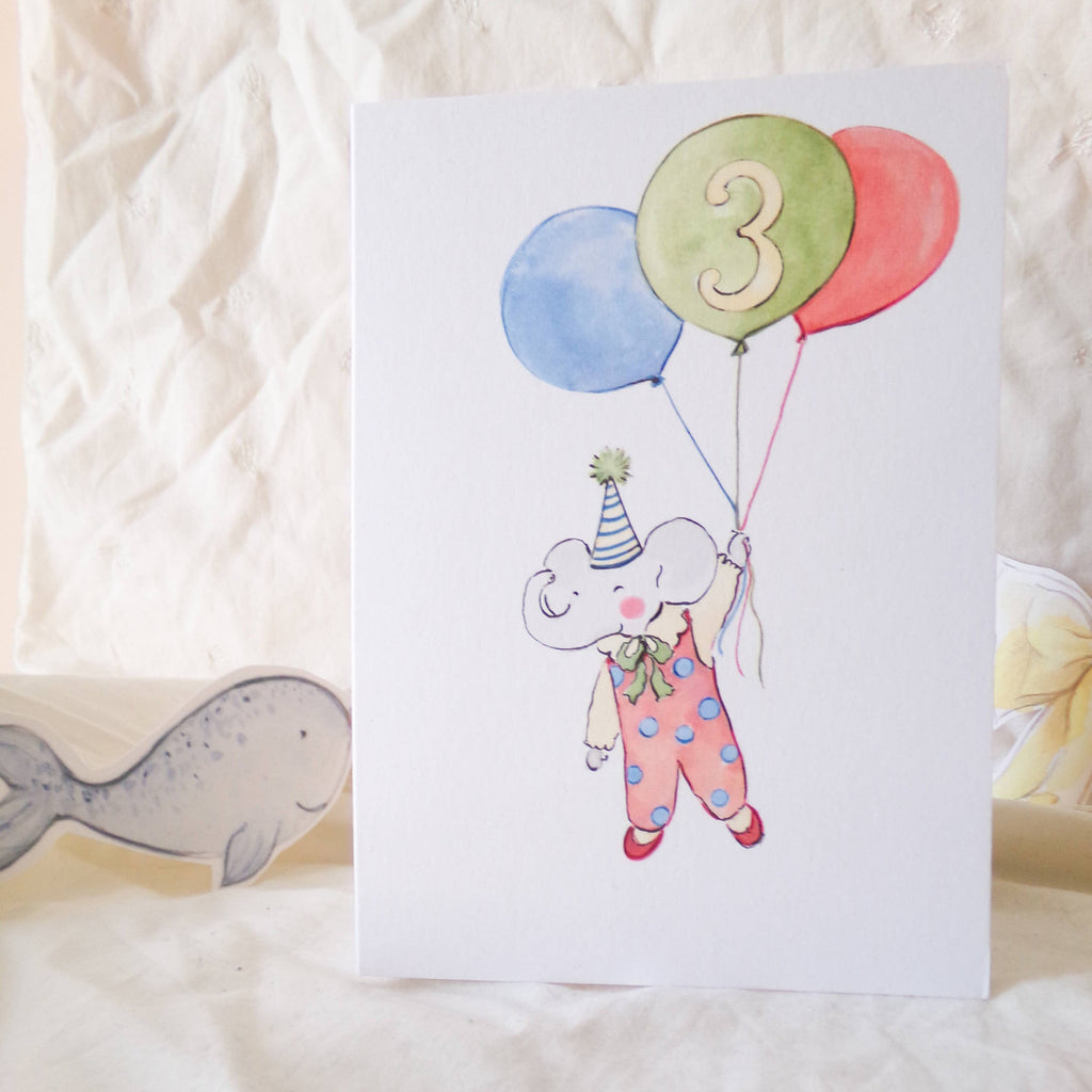Children's birthday card with a cartoon elephant holding balloons and the number 3 on a white background.