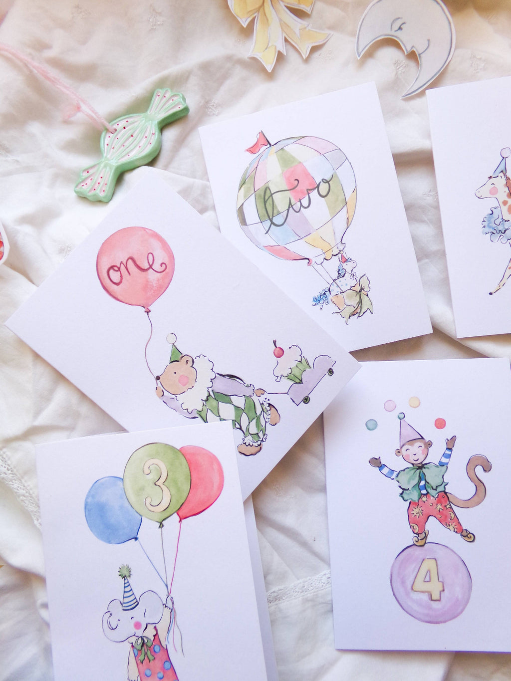Set of birthday cards with cartoon monkey characters and balloons on a soft surface.