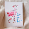 Card with a pink flamingo illustration and 'love your style' text on a soft fabric background