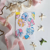 Sheet of decorative stickers with colorful designs on a white background with ribbons.