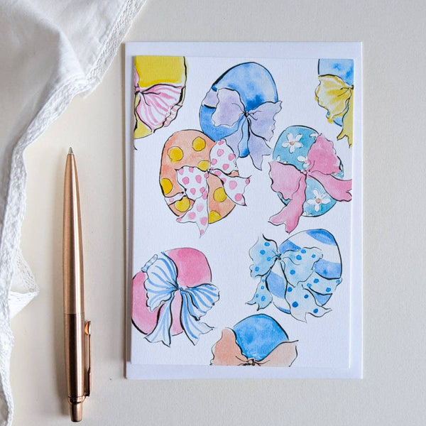 Notebook with colorful shell designs on a white surface with a pen next to it.