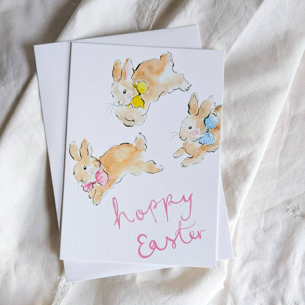 Greeting card with Easter-themed illustrations of bunnies on a white fabric background