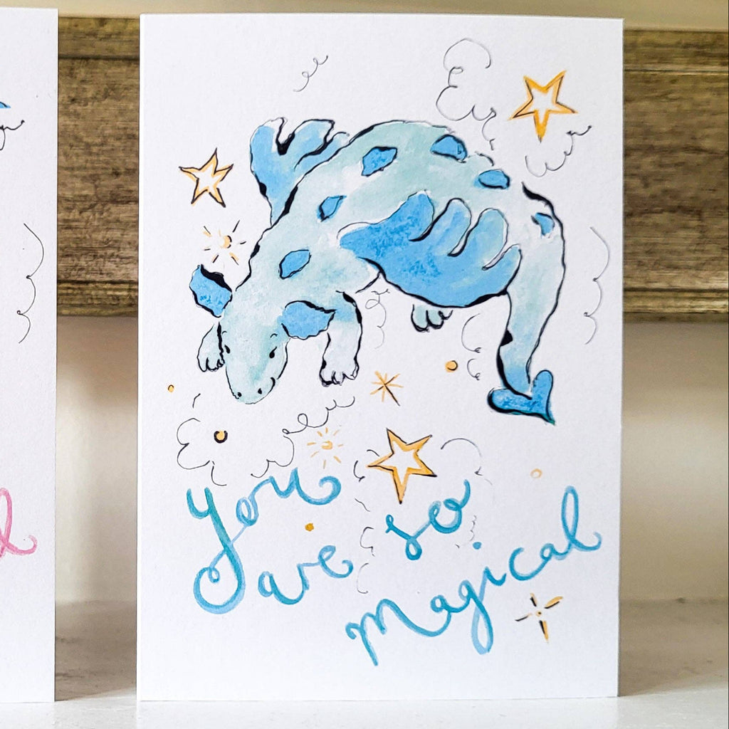 Two greeting cards with cartoon bulls and text 'You are so magical' on a wooden surface.