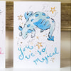 Two greeting cards with cartoon bulls and text 'You are so magical' on a wooden surface.