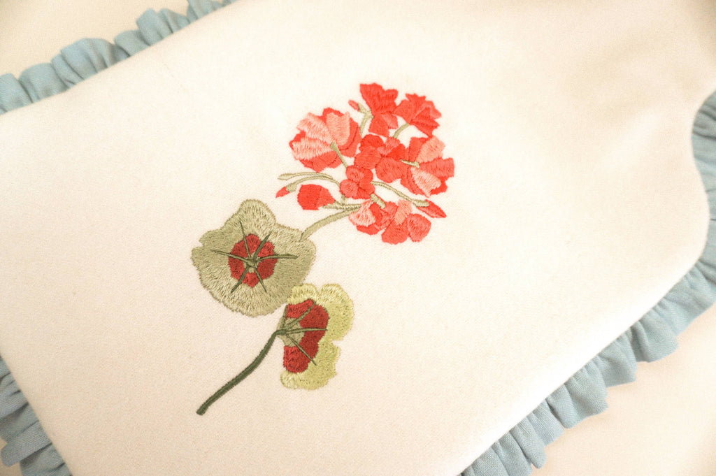 Decorative pillow with embroidered red flowers on a beige background