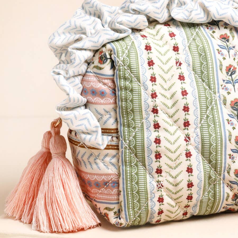 Decorative pillow with floral patterns and tassels on a beige background