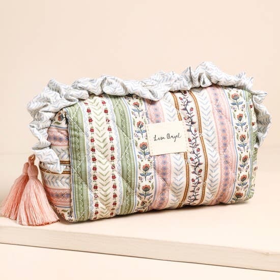 Decorative cylindrical pillow with ruffled top and tassels on a beige background