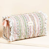 Roll of floral-patterned fabric with tassels on a beige background
