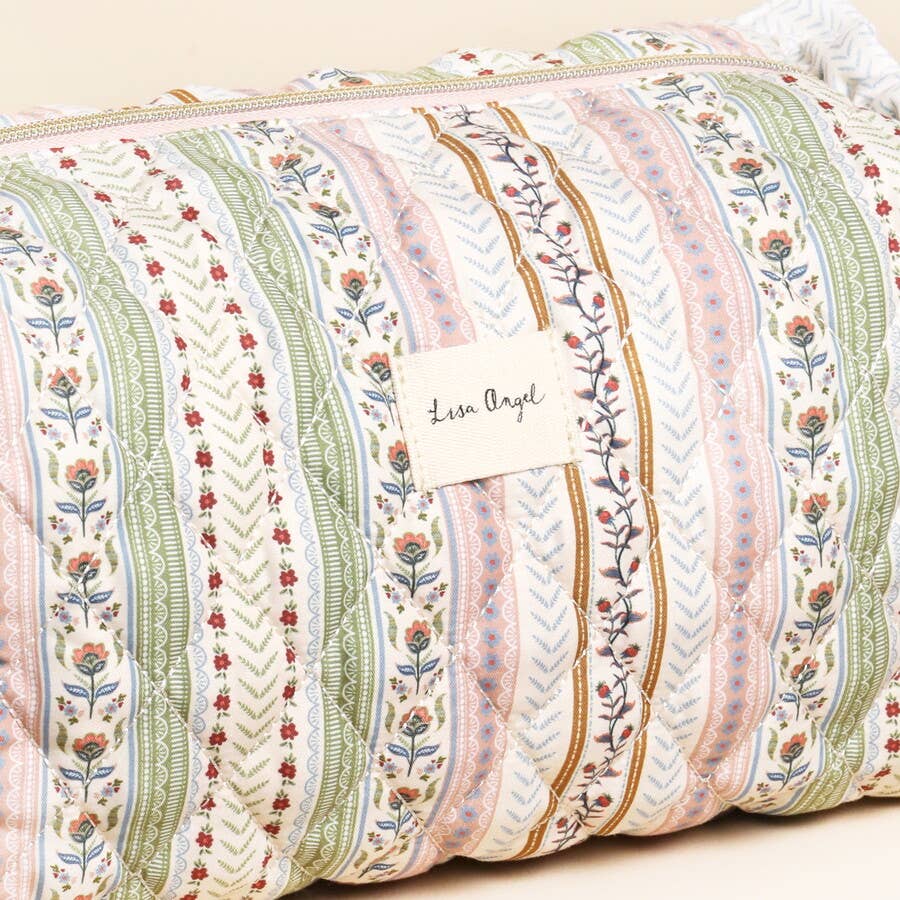 Decorative pillow with floral and stripe pattern and 'Lisa Angel' label.