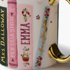 Mug with book-themed design featuring names and decorative elements on a white background.