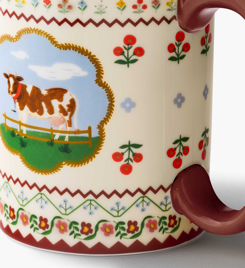 Mug with cow illustration and decorative patterns on a white background