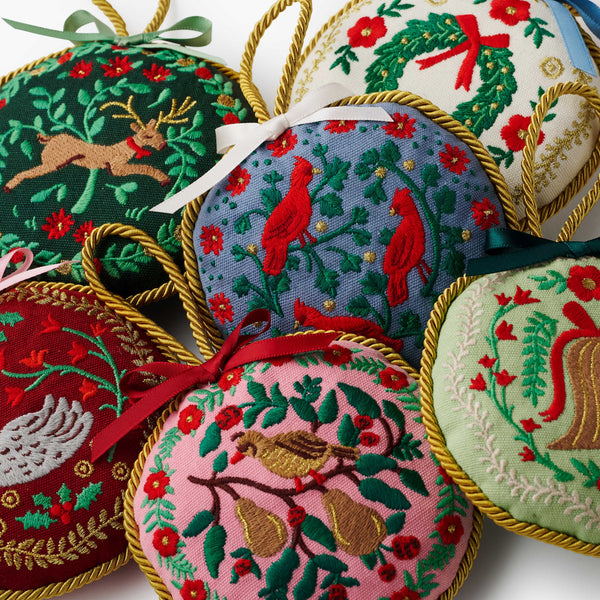 Collection of embroidered Christmas ornaments with various patterns on a white background