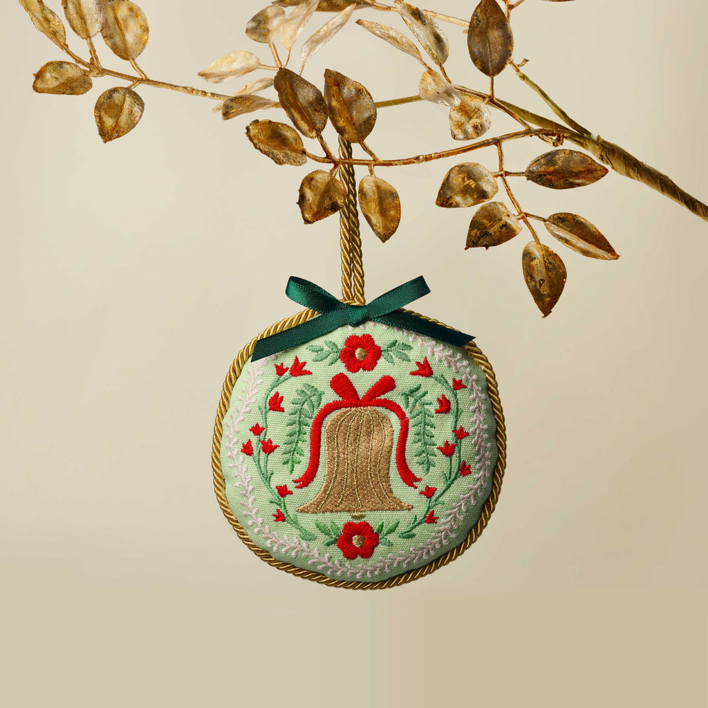 Embroidered ornament with a bell design on a beige background