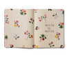Floral notebook with 'Month by Month' text on a beige background