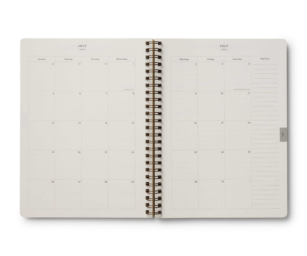 Open spiral-bound planner showing a monthly calendar layout on white background