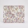 Floral-patterned bag with a visible brand tag on a light gray background
