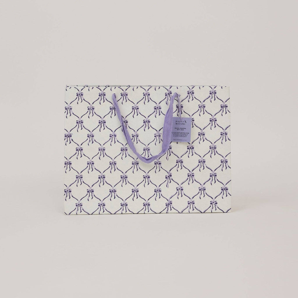 Patterned paper bag with a handle on a light gray background