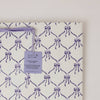 Block printed gift bag with purple bow pattern and 'paper mirchi' tag on a white background