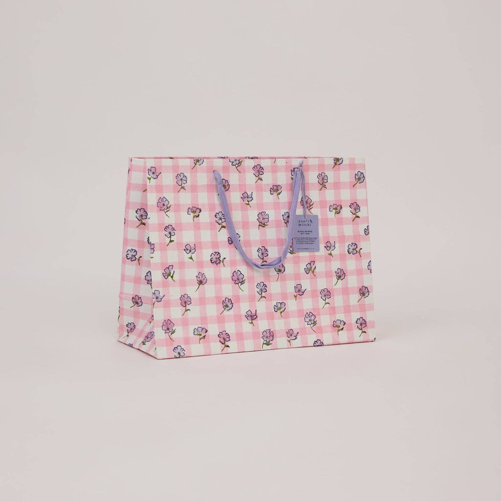 Floral patterned bag with a visible brand label on a light pink background