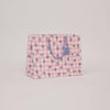 Floral patterned bag with a visible brand label on a light pink background