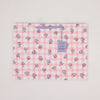 Floral-patterned fabric with a tag on a light gray background