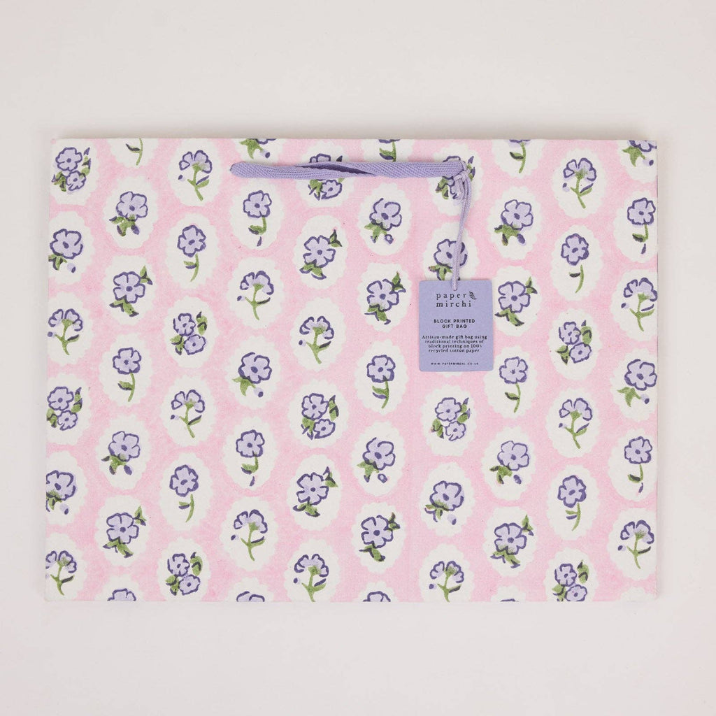 Floral-patterned blanket with a brand label on a light gray background