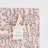 Gift bag with pink floral pattern and a visible brand tag on a matching pink background