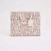 Floral patterned product packaging on a light pink background