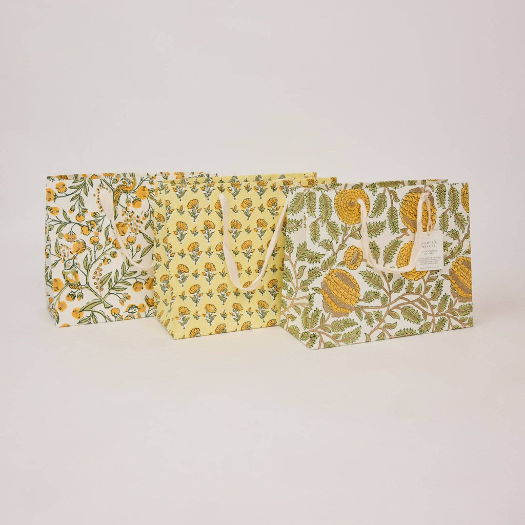 Set of three fabric bags with floral patterns on a light gray background