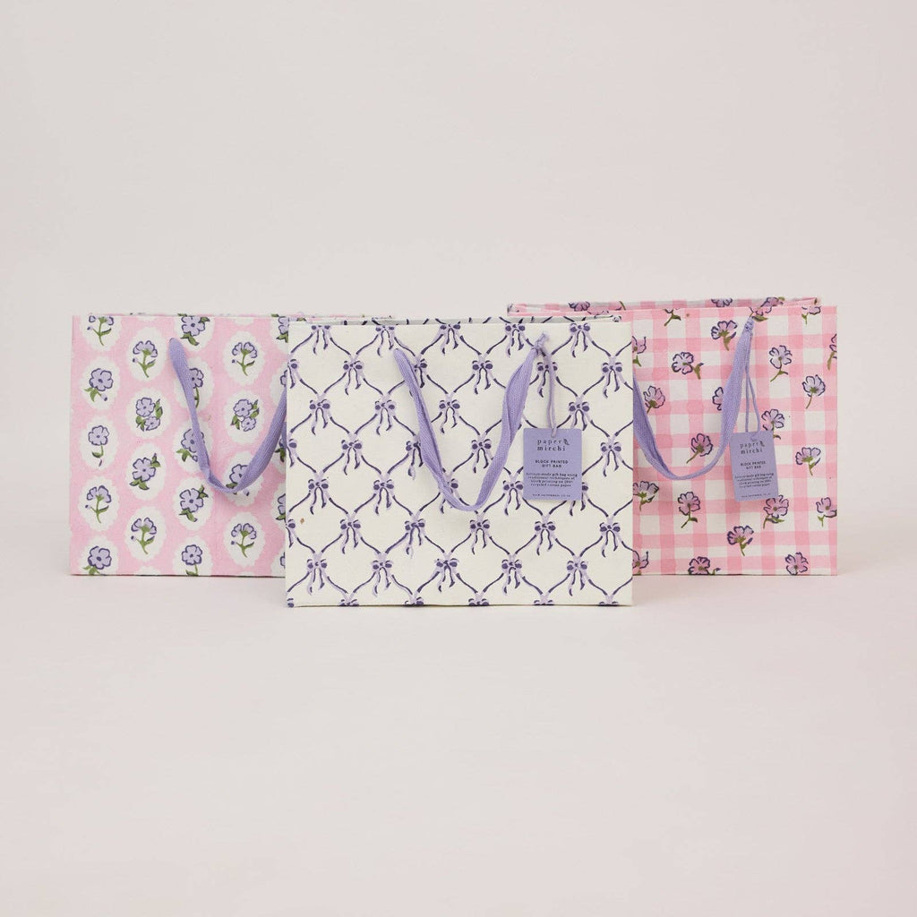 Two gift bags with floral and checkered patterns on a light gray background