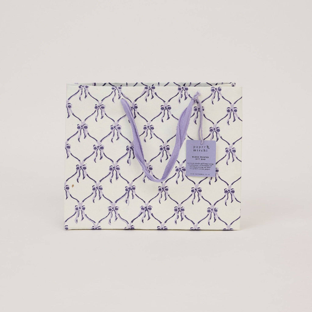 Gift bag with purple bow pattern on a white background