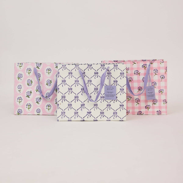 Two gift bags with floral and checkered patterns on a light gray background